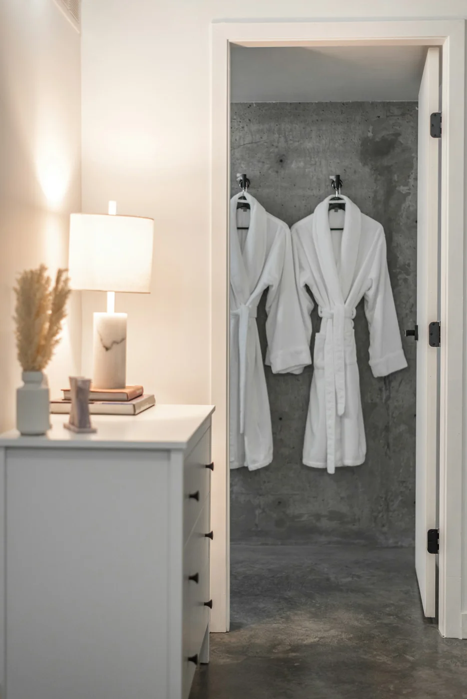 White bathrobes hanging in a refined hotel bathroom